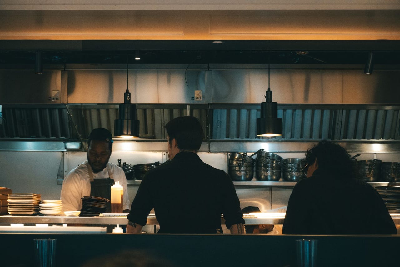 Busy shared kitchen line working through tickets.