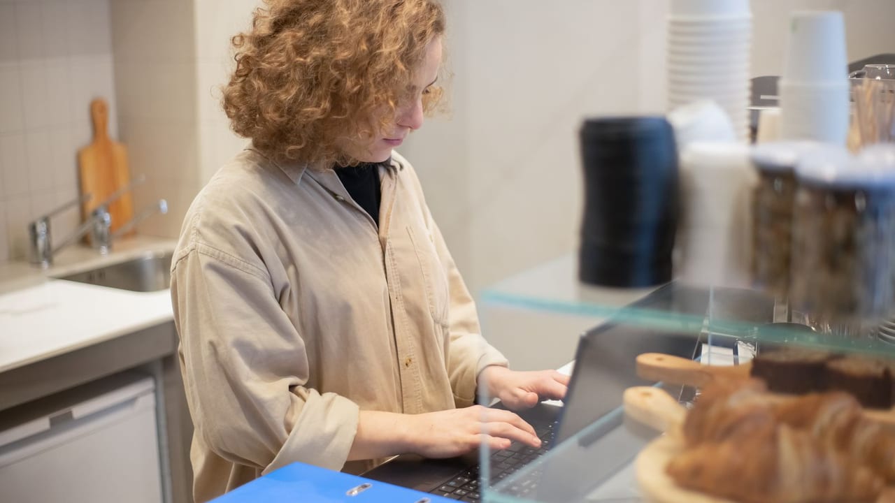 Manager assigning items to brands on a back-office laptop.