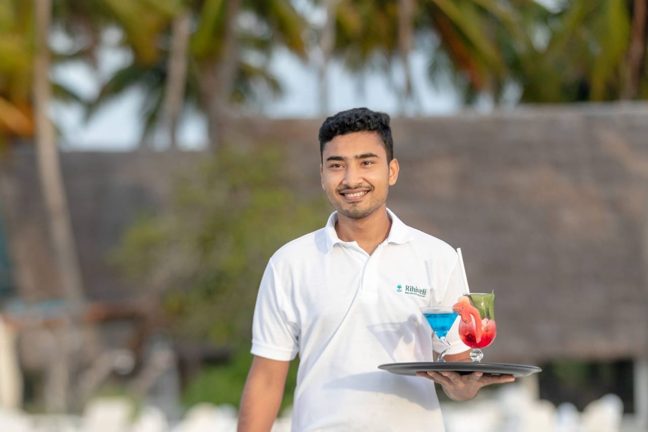 Resort server delivering drinks poolside.